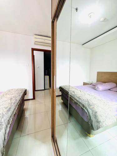 a bedroom with a mirror and a bed at Emaar Moslem Friendly Stunning Comfy 2BR Apartment at the heart of Jakarta in Jakarta