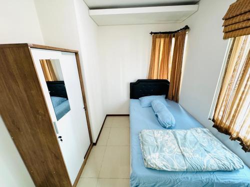 a small room with a bed and a mirror at Emaar Moslem Friendly Stunning Comfy 2BR Apartment at the heart of Jakarta in Jakarta