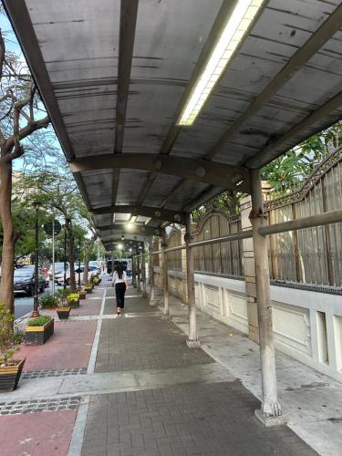 a person walking down a sidewalk under a bridge at Emaar Moslem Friendly Stunning Comfy 2BR Apartment at the heart of Jakarta in Jakarta