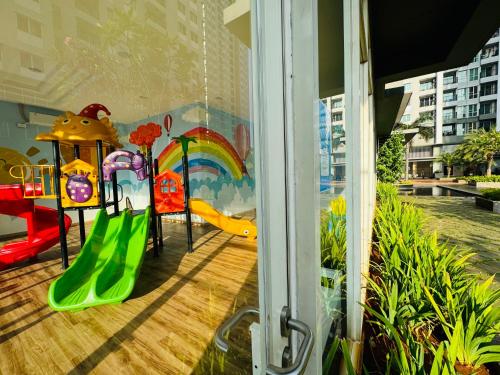 a room with a playground with a slide at Emaar Moslem Friendly Stunning Comfy 2BR Apartment at the heart of Jakarta in Jakarta