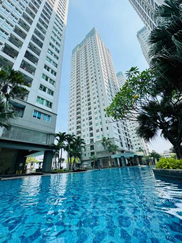 a large swimming pool in a city with tall buildings at Emaar Moslem Friendly Stunning Comfy 2BR Apartment at the heart of Jakarta in Jakarta
