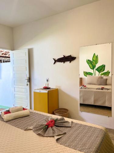 a bedroom with a bed with a fish on the wall at Pousada Nascente do Sol in Ilha de Boipeba