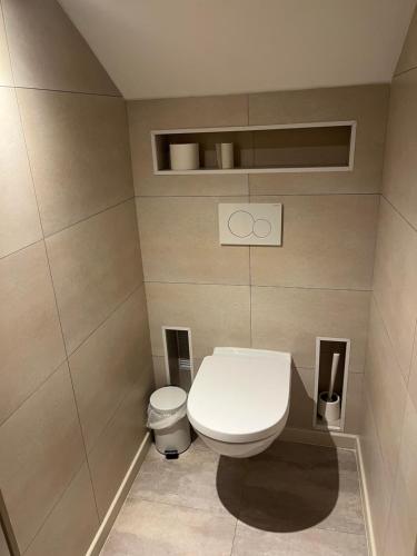 a bathroom with a white toilet in a room at Hôtel Le Roosevelt in Givet