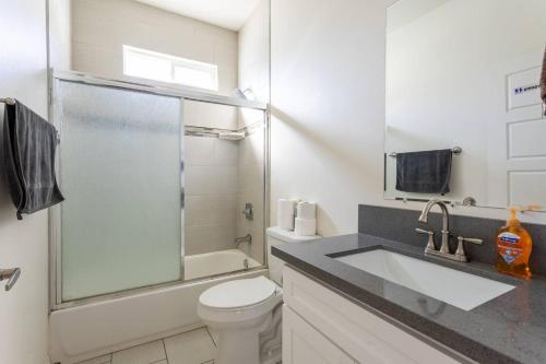 a white bathroom with a sink and a toilet at Getaway 4BR Home in the Heart of LA in Los Angeles