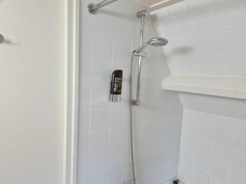 a shower in a bathroom with a black phone on the wall at Hotel Brull in Mechelen