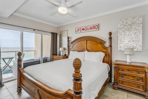 Un dormitorio con una cama de madera y vista al mar. en Emerald Isle Gulf Front 2B Condo - 707, en Pensacola Beach