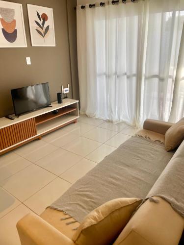 a living room with a couch and a television at Casa Com Piscina em Jacumã e Carapibus in Jacumã