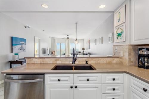 a kitchen with white cabinets and a sink at Emerald Isle Gulf Front 2B Condo - 1604 in Pensacola Beach