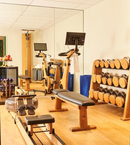 a gym with bikes and exercise equipment in a room at Maison Boissière BARNES Residences in Paris