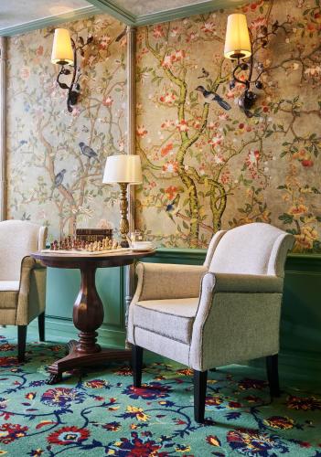 a room with two chairs and a table and a wallpaper at Maison Boissière BARNES Residences in Paris