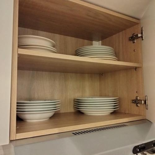 a cupboard with plates and bowls in it at Monolocale con veranda e giardino a Rio Marina in Rio Marina