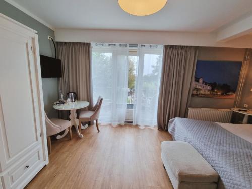 a bedroom with a bed and a table and a window at Hotel Brull in Mechelen