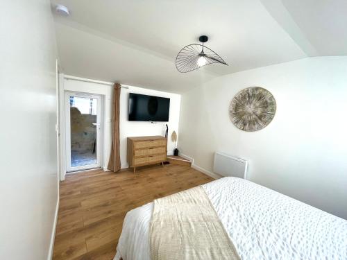 une chambre blanche avec un lit et une fenêtre dans l'établissement Le Numéro 2, à Saint-Jean-dʼAngély