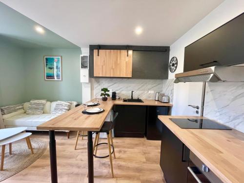 une cuisine et un salon avec une table et un canapé dans l'établissement Le Numéro 2, à Saint-Jean-dʼAngély