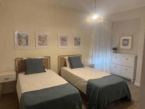 ein Schlafzimmer mit zwei Betten und einer Kommode in der Unterkunft Ca Maruja in Cullera