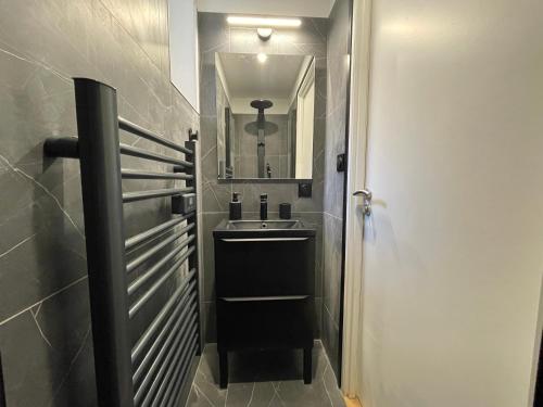 une salle de bain avec un lavabo et un miroir dans l'établissement Le Numéro 2, à Saint-Jean-dʼAngély