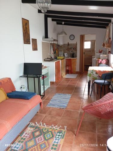 a living room with a couch and a kitchen at O Mundo da Lua in Azeitao