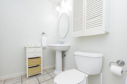 a white bathroom with a toilet and a sink at Emerald Isle Gulf Front 3B Condo - 1208 in Pensacola Beach