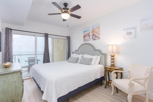 a bedroom with a bed and a ceiling fan at Emerald Isle Gulf Front 2B Condo - 805 in Pensacola Beach