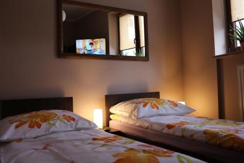 a bedroom with two beds and a mirror and a lamp at Noclegi Andersa in Wałbrzych