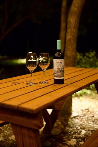 two wine glasses sitting on top of a wooden table at Casa Nengueta - Lapinha da Serra in Santana do Riacho