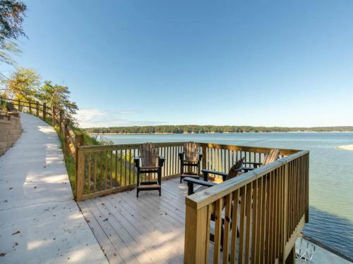 a wooden deck with chairs and tables next to the water at BEST VIEWS LAKE FRONT Waters Edge in Dandridge