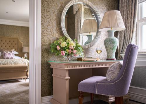 a bedroom with a dressing table and a mirror at Dromoland Castle in Newmarket on Fergus
