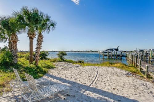 a beach with chairs and palm trees and a dock at Wave n Sea - Deep Water Cove 2B Townhome in Pensacola Beach