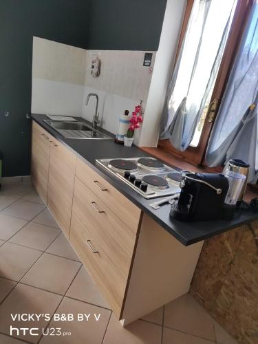 a kitchen with a sink and a stove in it at Vicky's B&B by V in Papasidero