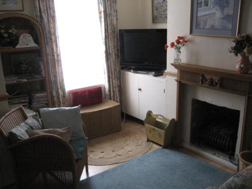 a living room with a fireplace and a television at Cosy character cottage conservation area in St. Albans