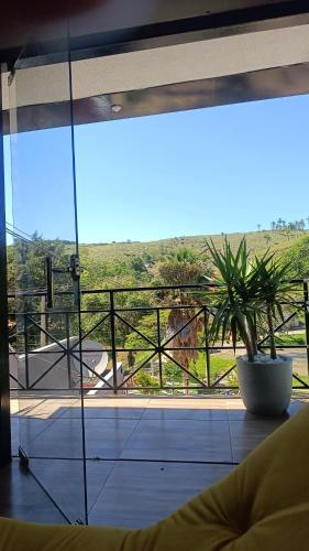 a room with a large window with a potted plant at Chacara Talismã in Jacareí