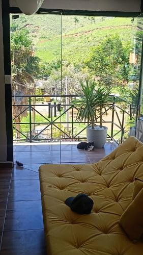 a couch in a living room with a large window at Chacara Talismã in Jacareí