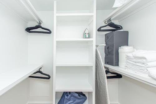 - un placard blanc avec des étagères et des serviettes blanches dans l'établissement Shipwatch 2B Gulf Front Condo - D603, à Perdido Key