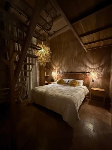 ein Schlafzimmer mit einem großen Bett und einem Kronleuchter in der Unterkunft Mitu in Purmamarca