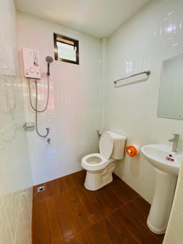 a bathroom with a toilet and a sink at ตาแอกะยายแดงโฮมสเตย์ in Ban Hong Khu