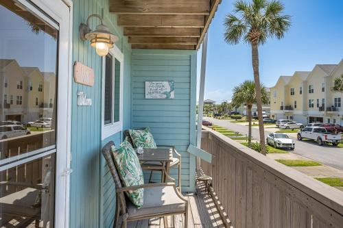 a blue house with two chairs on a porch at Sandy Dreams - 2B Townhome in Pensacola Beach