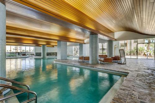 a large swimming pool in a building with blue water at Beach Club Gulf Front 3B Condo - 2003 in Pensacola Beach