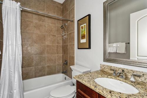 a bathroom with a sink and a toilet and a tub at Beach Club Gulf Front 3B Condo - 2003 in Pensacola Beach
