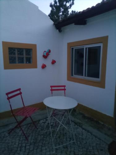 two chairs and a table in front of a building at O Mundo da Lua in Azeitao
