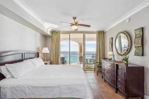 une chambre avec un lit et une commode avec un miroir dans l'établissement Beach Club Gulf Front 4B Condo - 1106, à Pensacola Beach