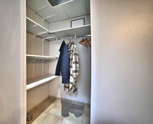 Elle comprend un dressing avec des murs et des étagères blancs. dans l'établissement Olympia - Terrasse, Parking gratuit, Thème Cinéma, Coeur de ville, Rez de chaussée, Fibre, Tv 4K, à Saintes