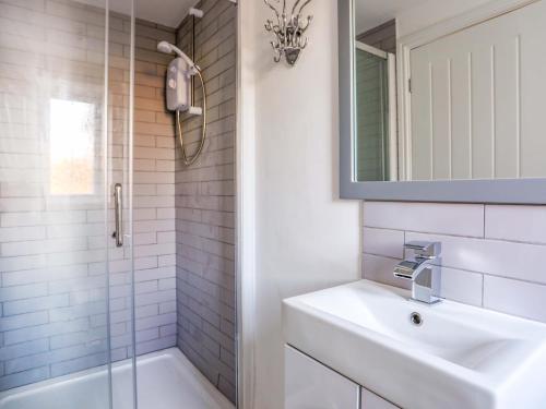 Un baño blanco con lavabo y ducha. en Ty'n Ffridd Bach, en Pwllheli