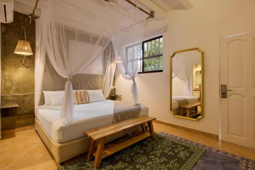 a bedroom with a white bed and a mirror at Fenix Beach Cartagena in Tierra Bomba