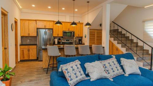 a living room with a blue couch and a kitchen at Casa Azul in Cruz de Huanacaxtle