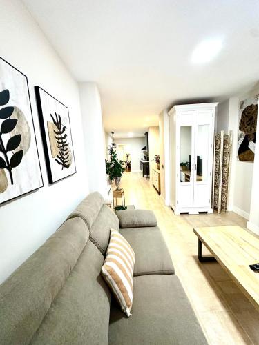 a living room with a couch and a table at Apartamentos Puente Romano Suites Parking Gratis in Merida