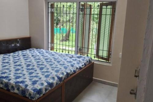 a bedroom with a bed in front of a window at Nakshatra Villa - A Relaxing Villa in Alibag in Revadanda