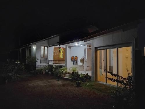a house lit up at night with a large glass door at Nakshatra Villa - A Relaxing Villa in Alibag in Revadanda