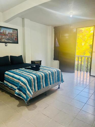 a bedroom with a bed with a colorful blanket on it at Hotel Luna in San Marcos La Laguna