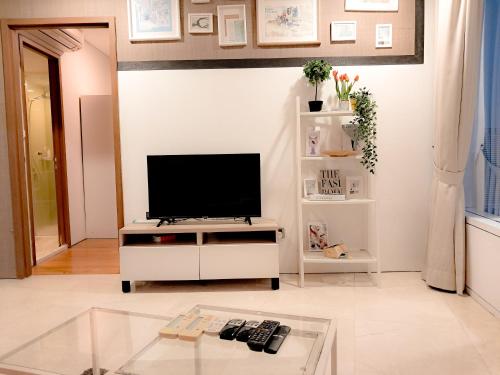 a living room with a television on a white cabinet at Vortex klcc by hr in Kuala Lumpur