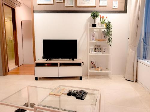 a living room with a television on a white cabinet at Vortex klcc by hr in Kuala Lumpur